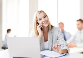 Blonde Frau im Coworking Space am telefonieren 