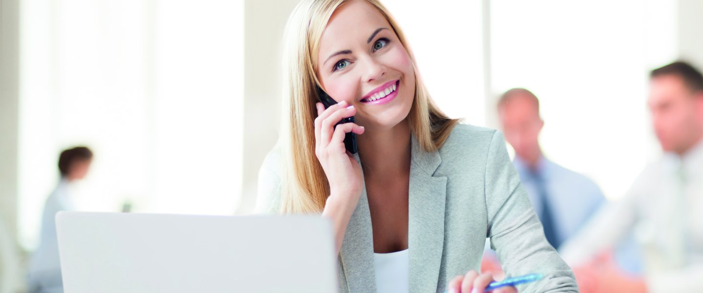 Online Anzeige Blonde Frau in Büro am telefonieren